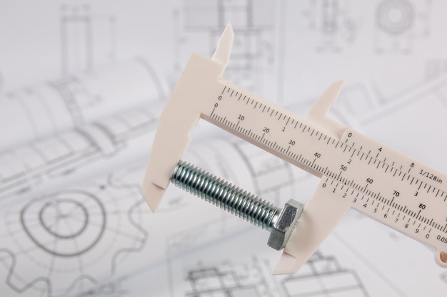 Nauwkeurige meting van metalen bout. Meten met technische schuifmaat.