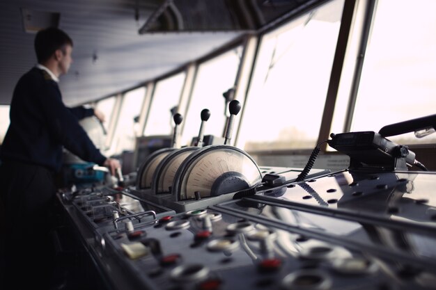 Navigatie officier rijden schip op de rivier.