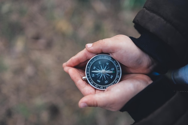 Navigation compass in hand Travel and camping in forest Finding path and direction