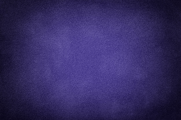 Navy blue matte felt background of suede fabric with vignette. Velvet texture of indigo textile with gradient.