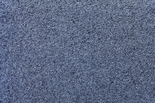 Navy blue sparkling background from small sequins, closeup. Denim metallic paper backdrop from foil. Kitchen surface countertop, macro.