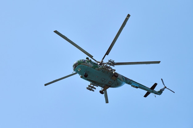 Photo navy helicopter flying against bright blue sky background, copy space. one military anti-submarine warfare helicopter demonstrating submarine search, bottom view