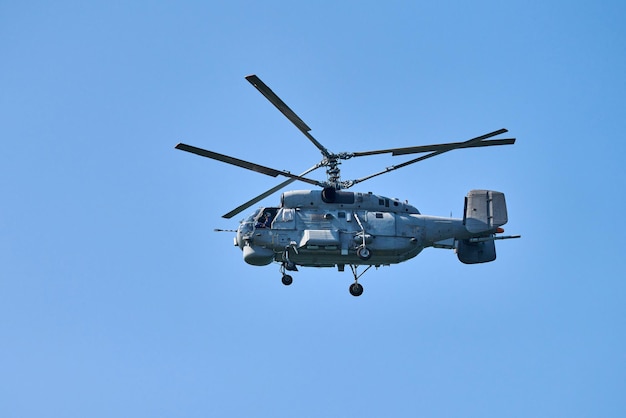 Navy helicopter flying against clear blue sky background, copy space. One rotary wing aircraft flying while doing demonstrations, side view