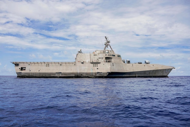 A navy ship is docked in the ocean.