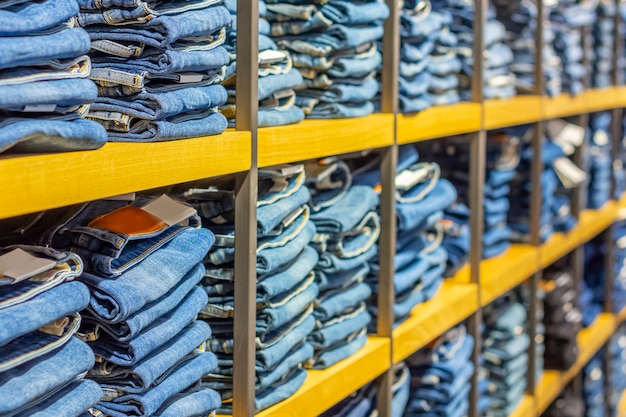 Photo neat stacks of folded jeans on the shop shelves