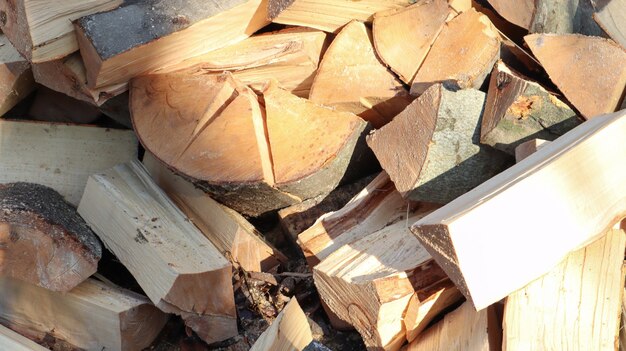 A neatly folded log of chopped wood. The fire is melting. Firewood stacked on top of each other. Firewood is collected for heating in cold weather. Background texture of stacked dry firewoods.