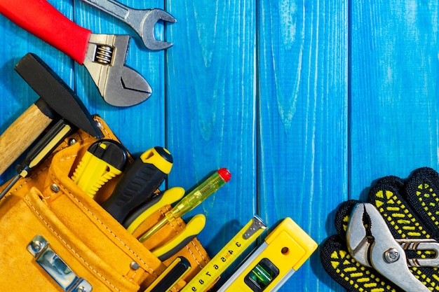 A necessary set of tools in a bag on a blue wooden background.. Also free space for advertising.