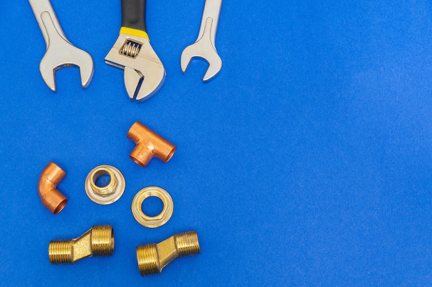 Photo necessary set of tools for plumbing isolated on blue background with space for advertising