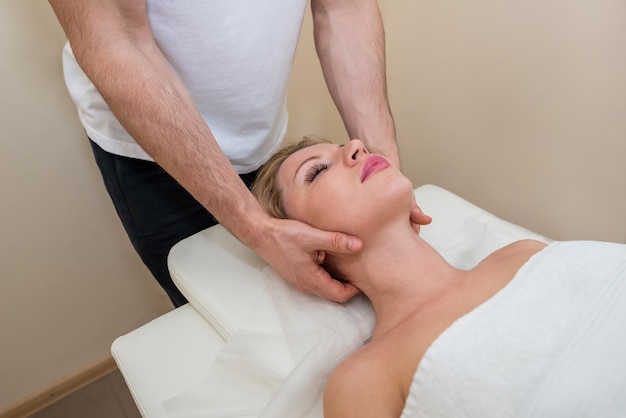 Neck massage in the spa salon for the girl. wellness massage concept. Male masseur massage blonde girl