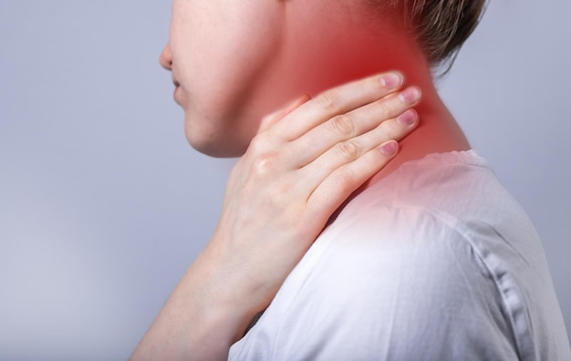 Neck pain close up Abstarct woman suffering from injury sprain discomfort massaging red point