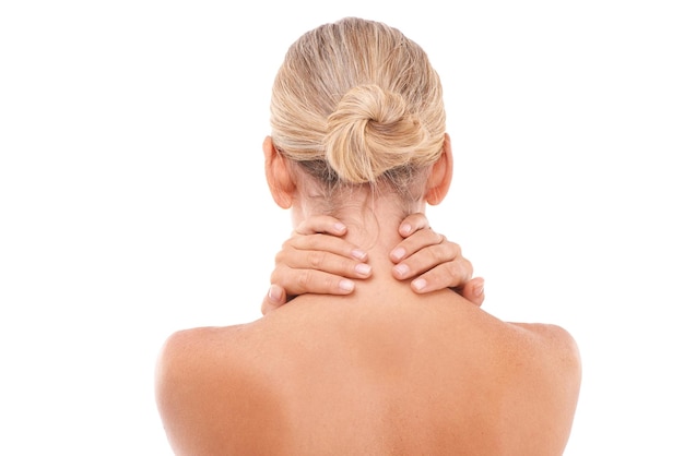 Neck pain injury and woman in a studio with discomfort stress or ache after a spa body care treatment Self care sore and back view of a female model with a muscle sprain by a white background