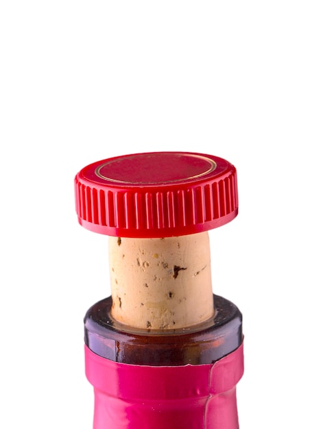 The neck of a wine bottle with a stopper and a red cap