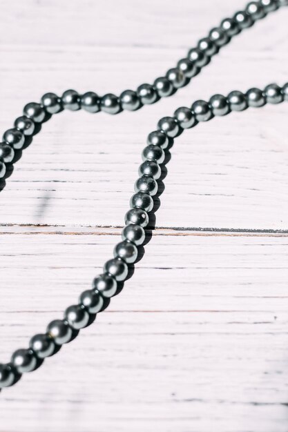 A necklace of gray beads on a white aesthetic background