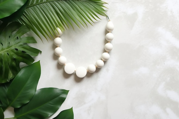 A necklace made from white beads and a green palm leaf