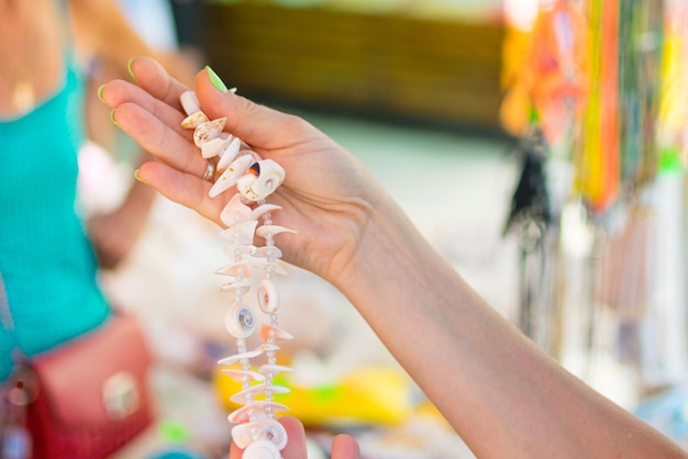 A necklace of seashells in women's hands