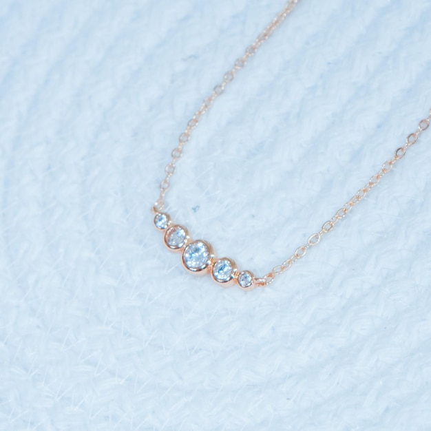 A necklace with a diamond and a gold chain.