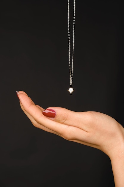 Foto una collana con un diamante su di essa è tenuta in mano