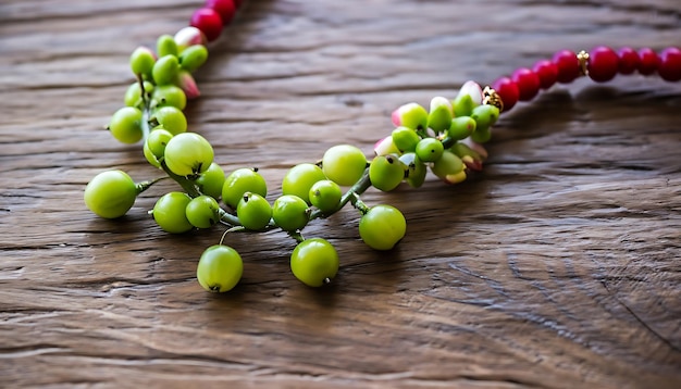 A necklace with green and red beads on a wooden table.