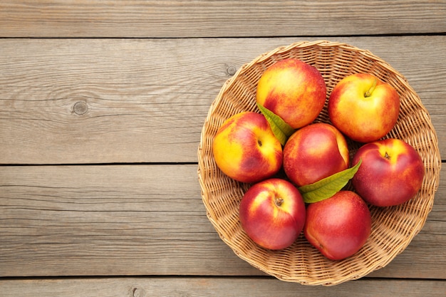 Nectarines in a basket on grey