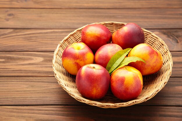 Nectarines in een mand op bruin