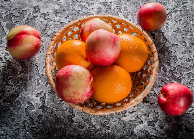 Nectarines and oranges in a plate of fresh fruit