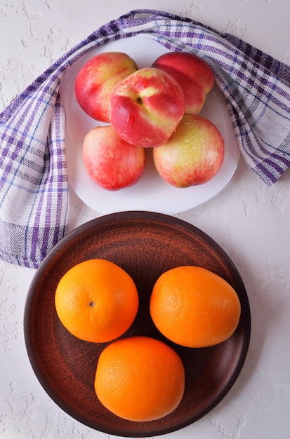 Nectarines and oranges in a plate of fresh fruit