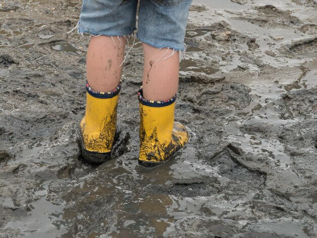 Foto nederig deel van het kind dat op modder staat