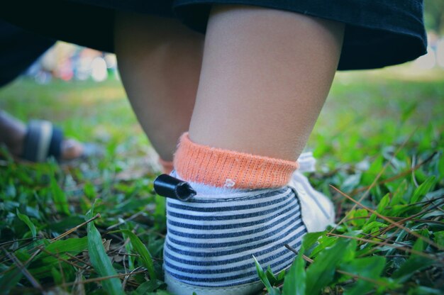 Foto nederig gedeelte van baby die schoenen draagt op het gras