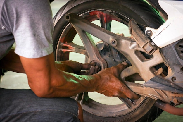 Foto nederig gedeelte van de man die op een motorfiets werkt