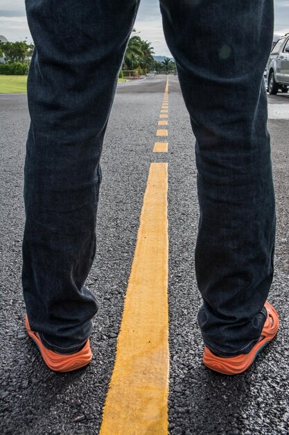 Foto nederig gedeelte van een man die op de weg staat