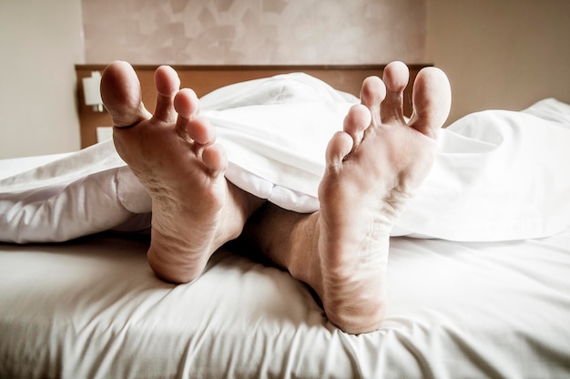 Nederig gedeelte van een man die op het bed rust
