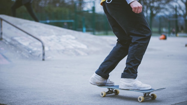 Foto nederig gedeelte van een man die skateboardt op beton