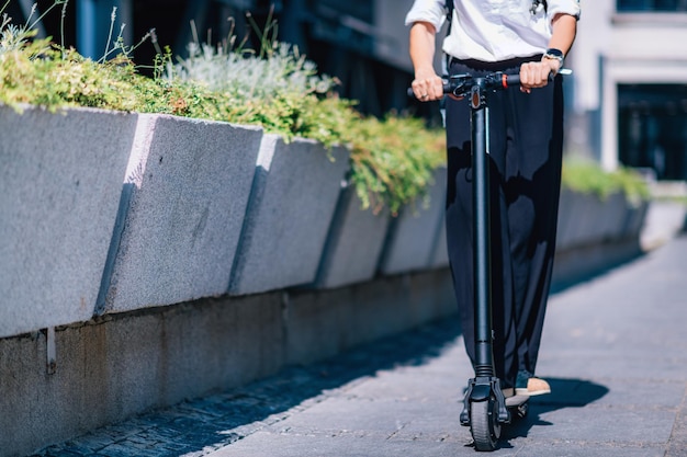 Nederig gedeelte van een man op een schroefscooter aan de kant van de weg