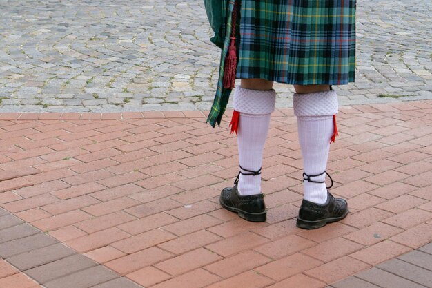 Nederig gedeelte van een persoon in traditionele kleding die op een voetpad staat