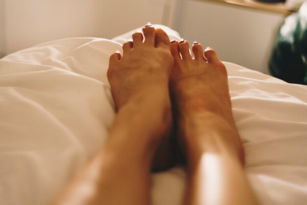 Foto nederig gedeelte van een vrouw die ontspant op het bed