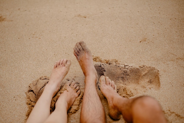 Nederig gedeelte van een vrouw die ontspant op het zand op het strand