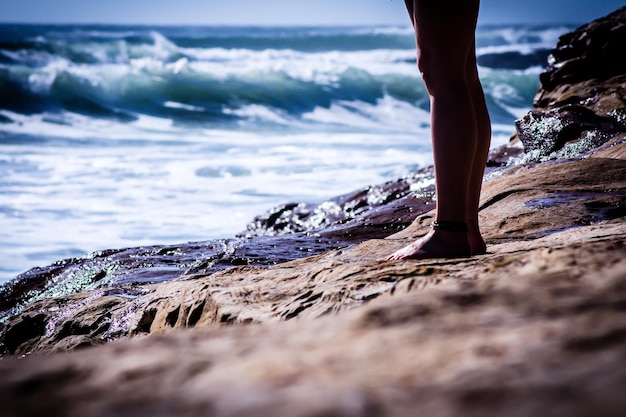 Nederig gedeelte van een vrouw die op het strand staat