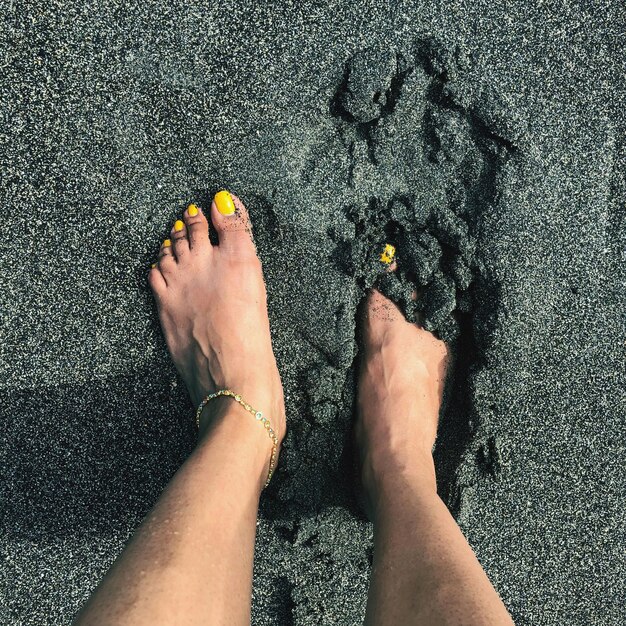 Foto nederig gedeelte van een vrouw die op het strand staat