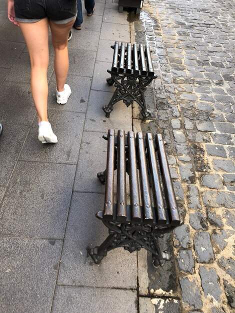 Foto nederig gedeelte van een vrouw die op het voetpad loopt