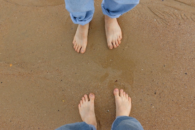 Nederig gedeelte van man en vrouw die aan de kust staan