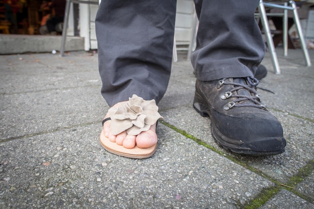 Foto nederig gedeelte van persoon die schoen en pantoffel draagt terwijl hij op de stoep staat