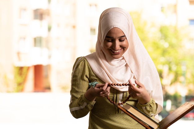 Nederige moslimvrouw bidt met de Koran