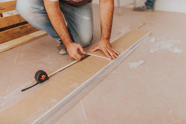 Nederige sectie van een timmerman die hout meet in een werkplaats