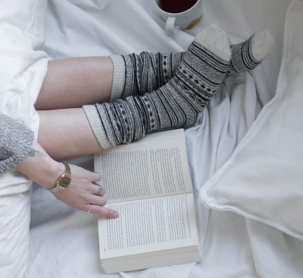Foto nederige sectie van vrouw met boek op bed