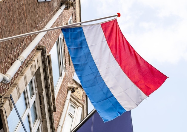 Nederlandse vlag op fasad gebouw tegen Blue Sky in