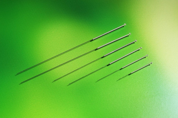 Needles for acupuncture on green background