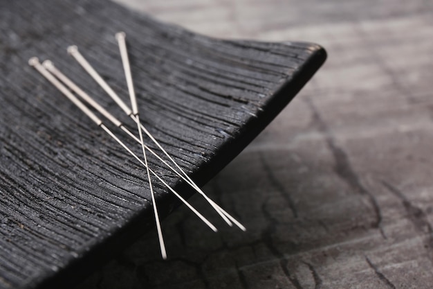 Needles for acupuncture and special stand on grey background closeup