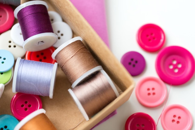写真 裁縫、工芸、縫製、仕立てのコンセプト – テーブルの上に糸のスプールとボタンが入ったボックス