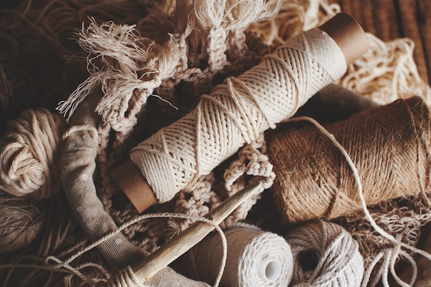 針仕事、マクラメ、編み物。籐のかごの中の自然な色の毛糸と糸。女性の趣味。