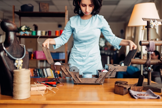 Strumenti e attrezzature per il ricamo, maestro femminile sul posto di lavoro in officina. accessori artigianali. arredamento di moda fatto a mano